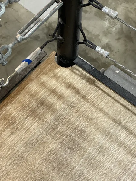 Flooring follows the wall and railing at the landing corner.