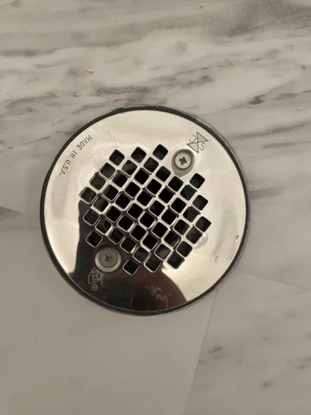 Carefully shaped cuts follow the circular opening, keeping the finished flooring edge close to the drain cover.