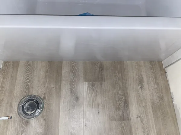 This homeowner preferred a clean caulk line instead of a rubber protection strip. We carefully fitted the tubs edge, leaving a crisp neat line for the caulk finish.
