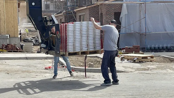 Equipment and crew activity outside the buildings during construction.