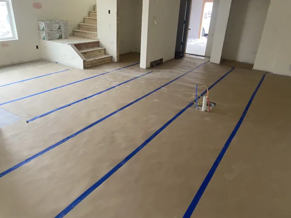Protective paper and taped seams cover the floor during ongoing construction.