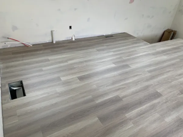 Wood-look plank flooring across the room near the walls and window.