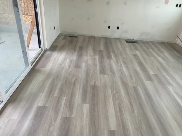 Wood-look plank flooring across the room near the walls and window.