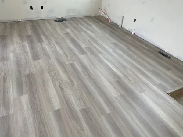 Wood-look plank flooring across the room near the walls and window.