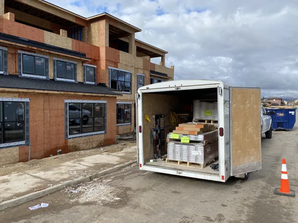 A trailer and construction access beside the community buildings.