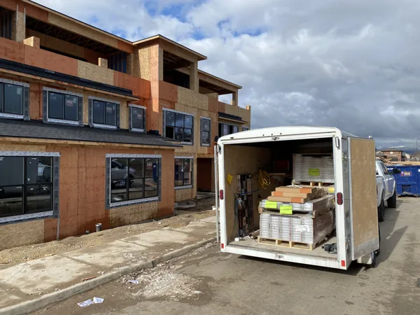 A trailer and construction access beside the community buildings.