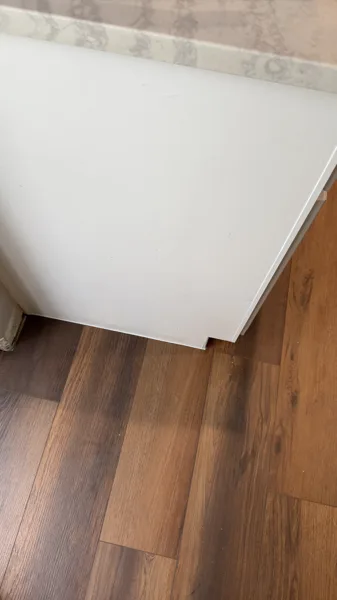 A close view of the flooring edge at the kitchen cabinetry. Product-specific expansion requirements must be reviewed for each installation.